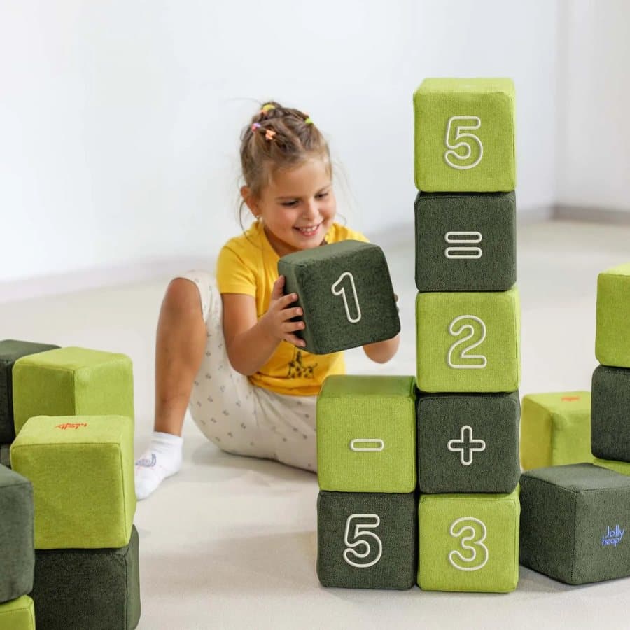 A girl building sums with digits and signs from JollyHeap Numo blocks