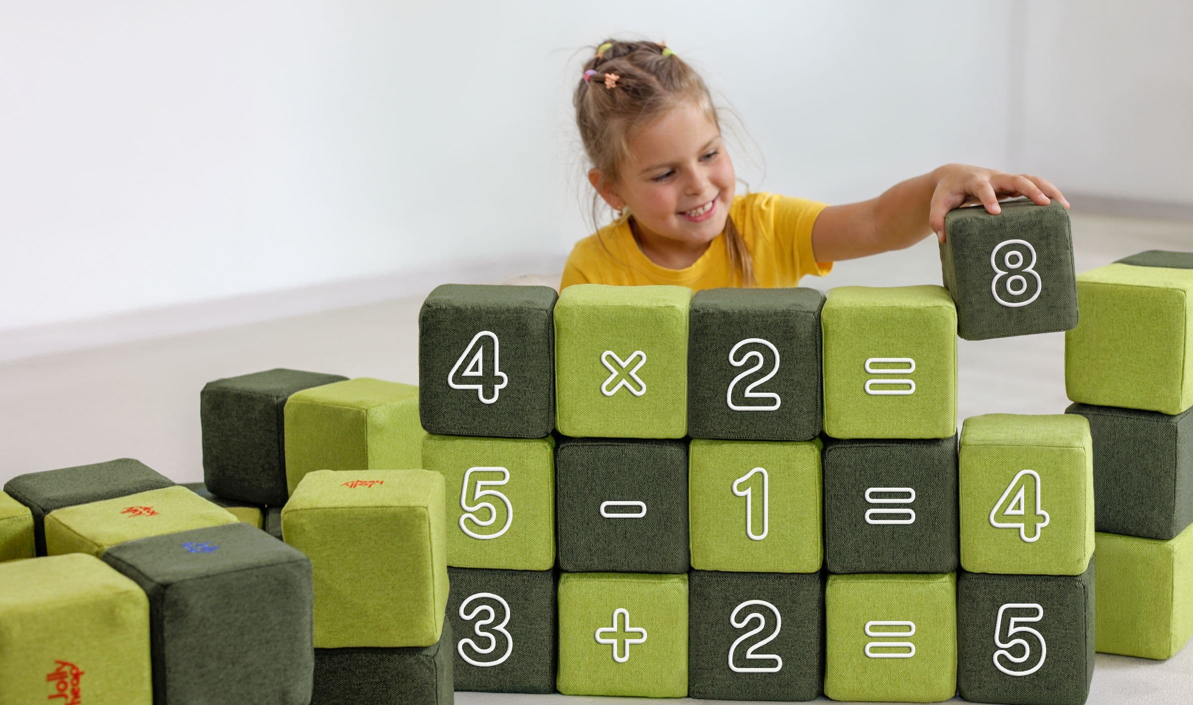 A girl adding a green JollyHeap Numo block with the digit 8 to number sentences built from blocks