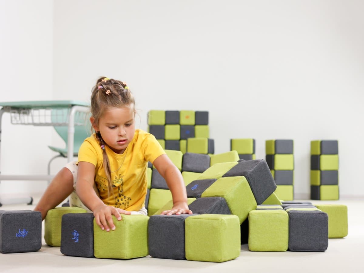 A girl rearranging blocks in a room