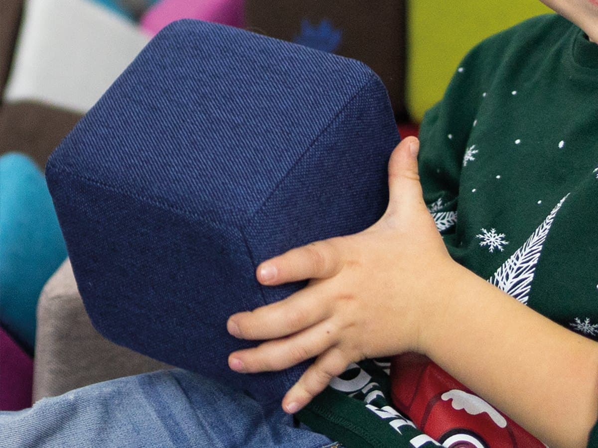 Close-up of a child hand gripping a navy JollyHeap block